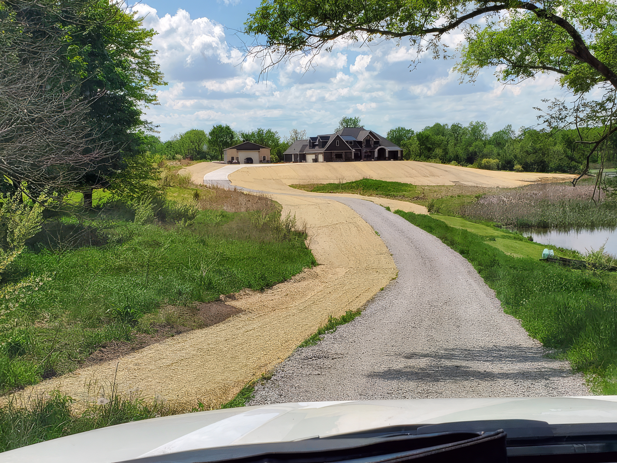 large graded and seeded yard in front of a large home with a long driveway large graded and seeded yard in front of a large home with a long driveway