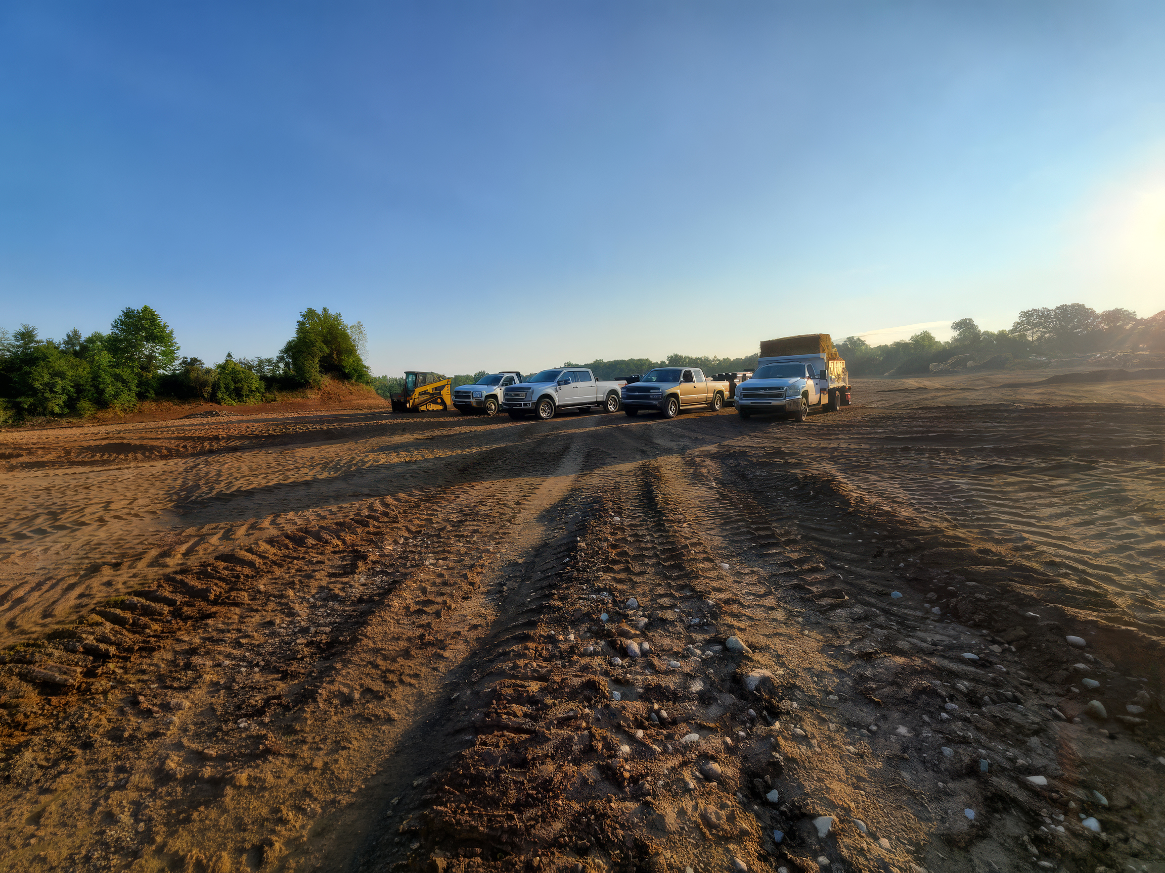 work trucks in large dirt field work trucks in large dirt field