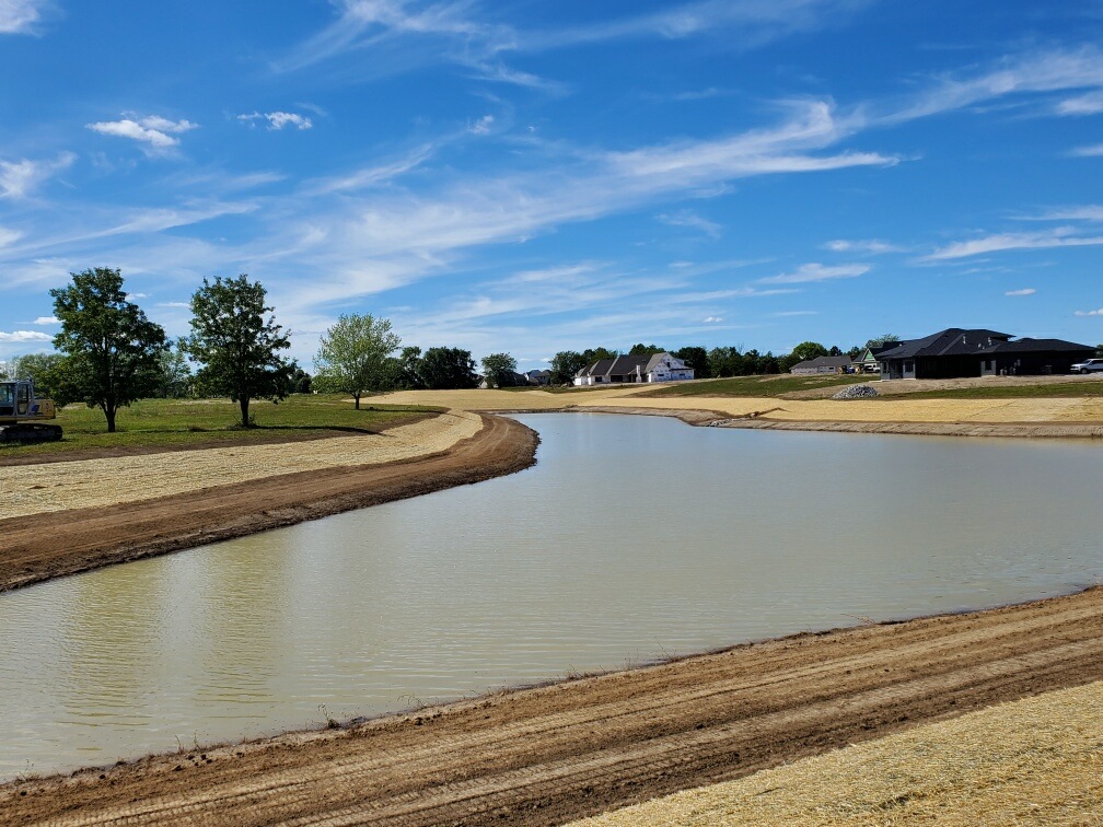 fresh straw surrounding a retaining pond in a subdivision fresh straw surrounding a retaining pond in a subdivision