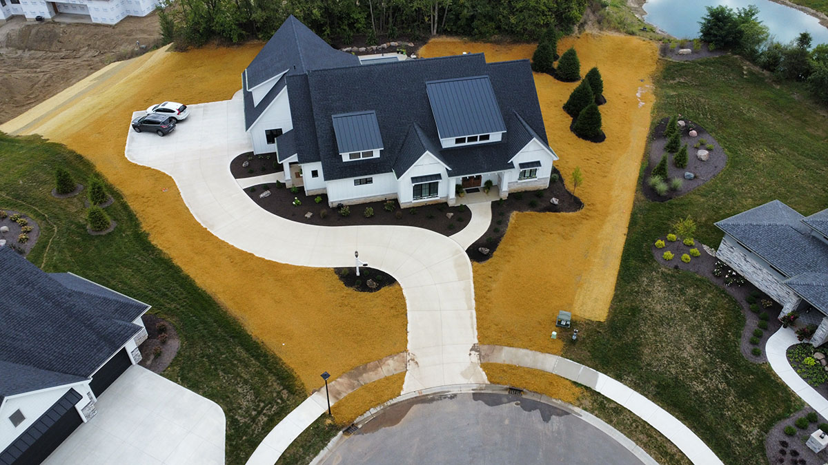 aerial view of a large white home with a yellow yard aerial view of a large white home with a yellow yard